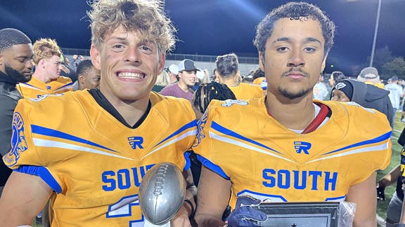 Two South players pose after the Lions All-Star Football Game, celebrating the South win.